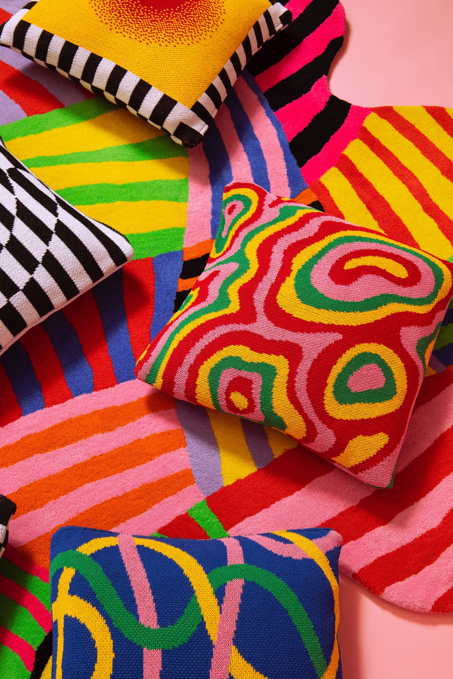 Various knit pillow covers laying on top of the squiggle stripe rug.