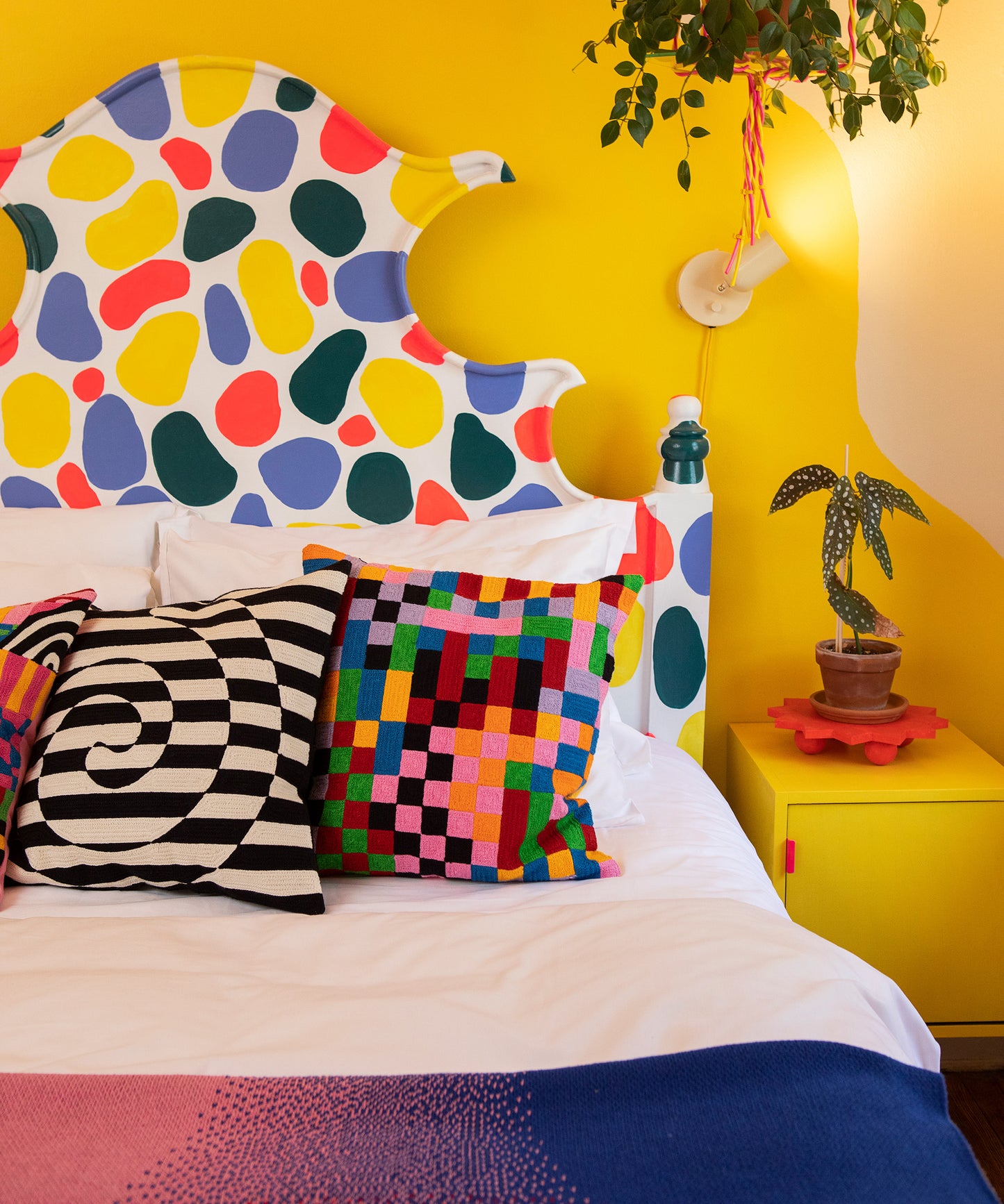 Detail of the Dazzle Pillow placed on top of a made bed standing next to the Pixel Pillow Cover.