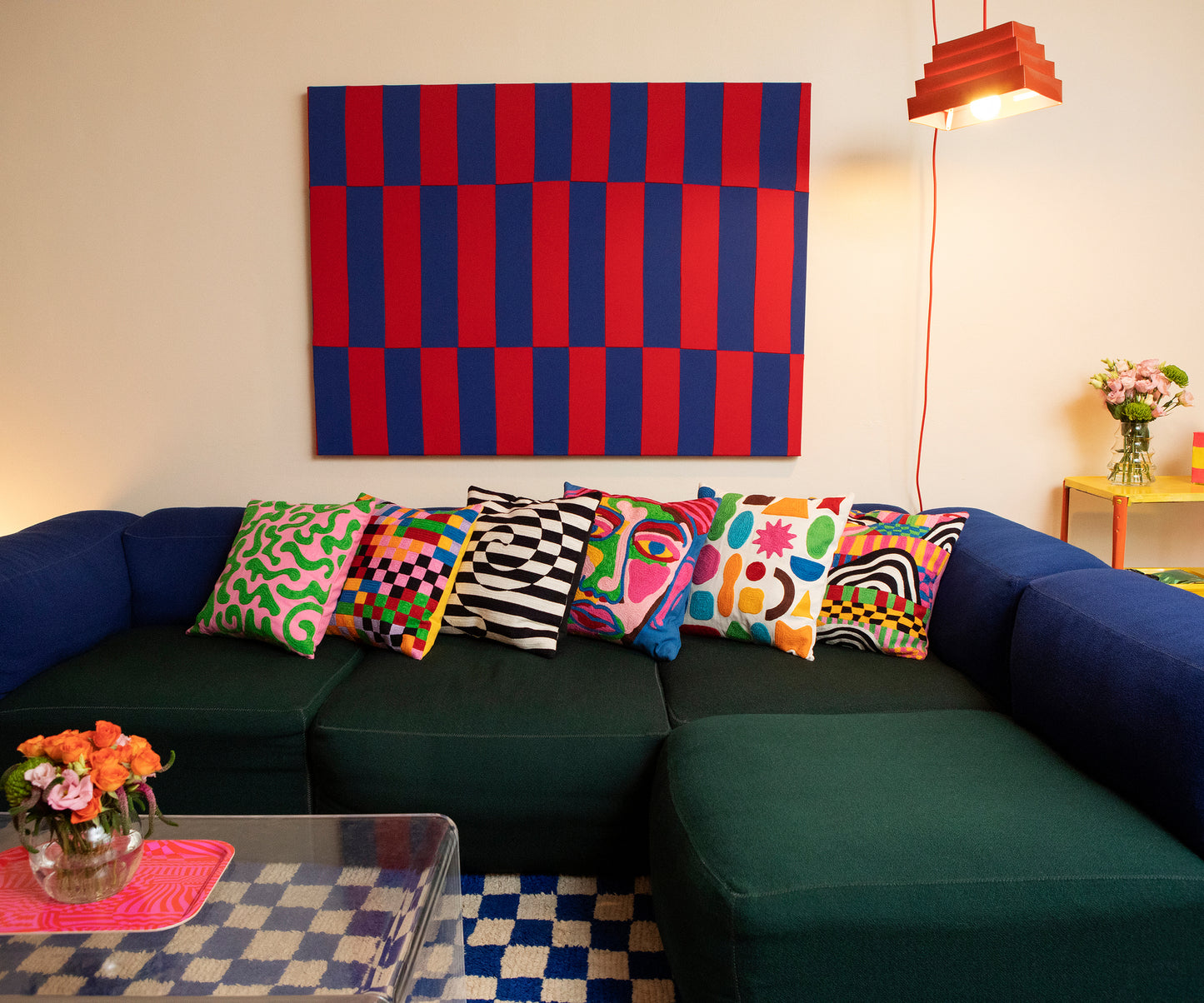 Detail of Silly Squiggles pillow displayed horizontally on a blue and green couch amongst the other 5 pillow cover designs from the 2022 Fall Collection.