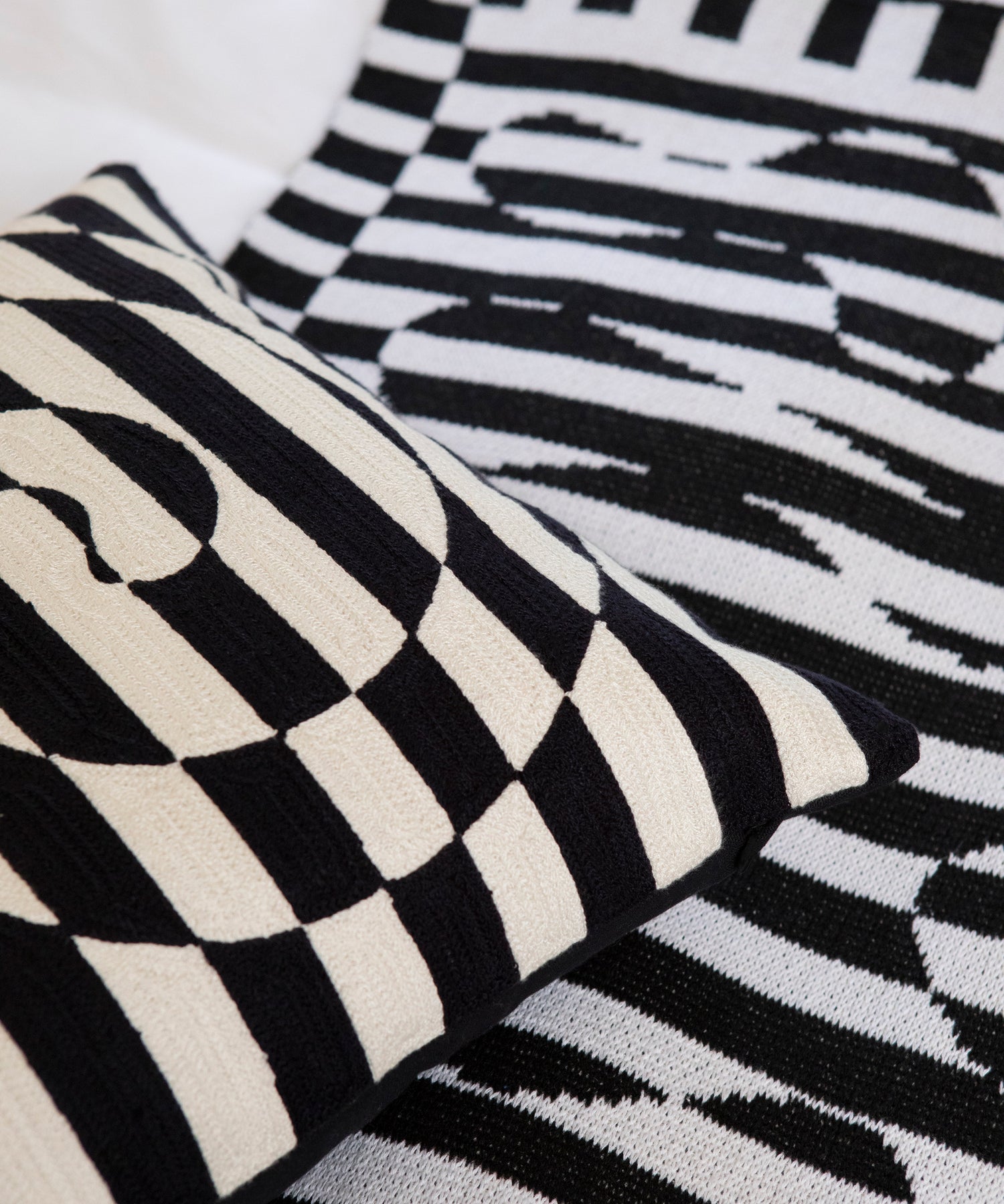 Detail image of Dazzle Pillow Cover placed on top of the Dazzle Blanket. 